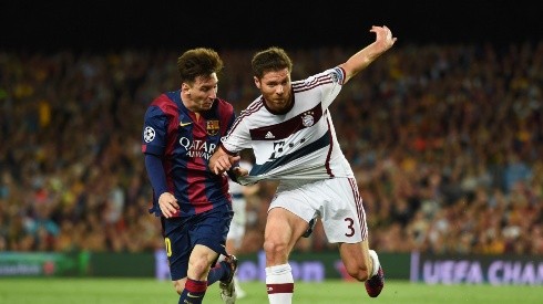 Xabi Alonso disputa el balón con Lionel Messi