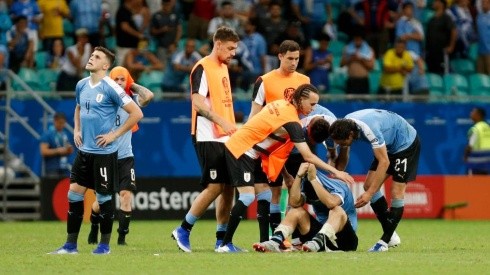 Jugadores de Uruguay levantando anímicamente a Luis Suárez.