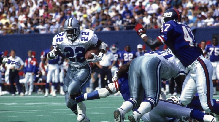 Emmitt Smith running away from the defense (Getty)