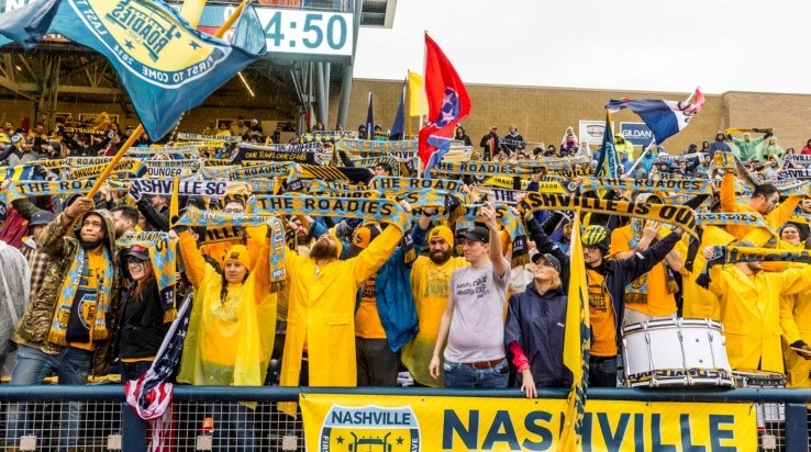 Nashville SC Supports holding flags during the teams first game. (nscroadies.com)