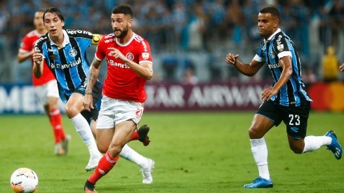 Boschilia of Internacional kicks the ball against Jeromel and Alisson of Gremio during the match for the Copa CONMEBOL Libertadores 2020