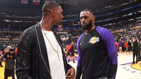 Chris Bosh (left) talks with LeBron James (right) during a Lakers-Raptors game. (Getty)