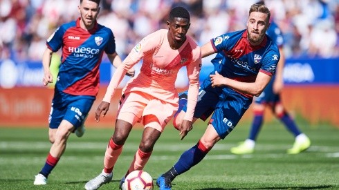 Ousmane Dembele of FC Barcelona (centre) duels for the ball with Jorge Pulido of SD Huesca (right). (Getty)