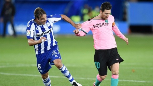 Tomas Pina (left) of Deportivo Alaves pulls the shirt of Lionel Messi (right) of Barcelona. (Getty)