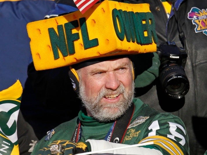 Two Green Bay Packers fans wear different style cheese head hats