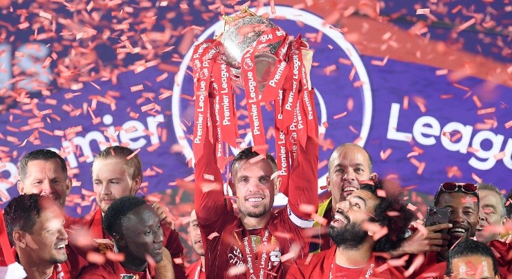 Jordan Henderson of Liverpool (centre) holds the Premier League Trophy aloft. (Getty)