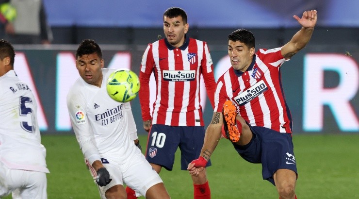Luis Suarez of Atletico Madrid (right) shoots under pressure from Casemiro of Real Madrid (left). (Getty)