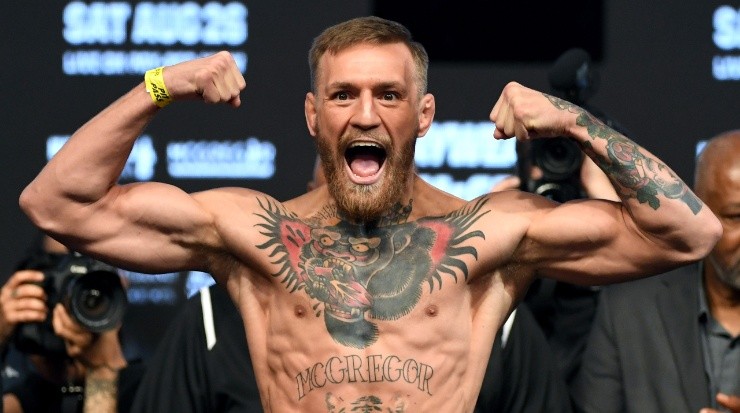 Conor McGregor poses on the scale during his official weigh-in (Getty)