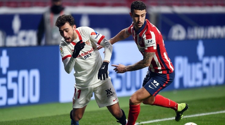 Munir El Haddadi of Sevilla (left) is fouled by Mario Hermoso of Atletico Madrid (right). (Getty)