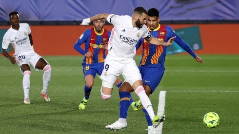 Karim Benzema (centre) of Real Madrid scores a goal vs Barcelona.