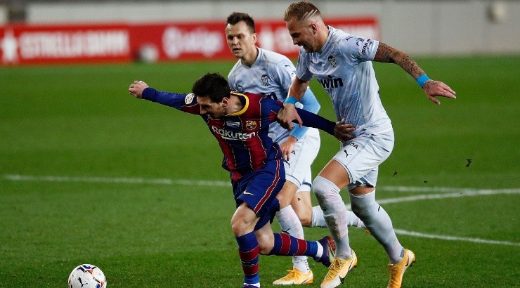 Lionel Messi (center) of Barcelona is put under pressure by Uroc Racic (right) of Valencia. (Getty)