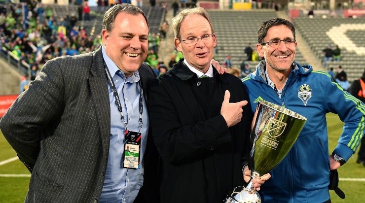 Head Coach Brian Schmetzer of the Seattle Sounders smiles as he holds the MLS Western Conference trophy between General Manager Garth Lagerwey and owner Adrian Hanauer after a 1-0 win over the Colorado Rapids at Dick&#039;s Sporting Goods Park on November 27, 2016 in Commerce City, Colorado. (Getty)