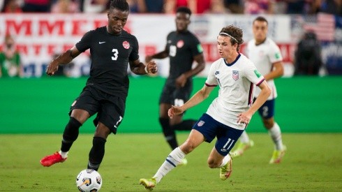 Samuel Adekugbe #3 of Canada passes the ball away from Brenden Aaronson #11 of United States