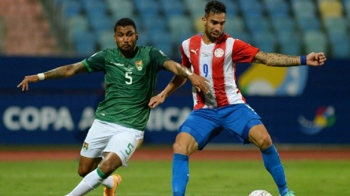 Adrian Jusino of Bolivia (left) fights for ball control against Gabriel Avalos of Paraguay