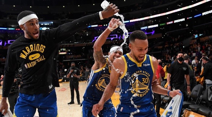Stephen Curry #30 of the Golden State Warriors is showered with water by his teammates Gary Payton II #0 and Damion Lee #1 as they celebrate after defeating the Los Angeles Lakers 121-114 (Photo by Kevork Djansezian/Getty Images)