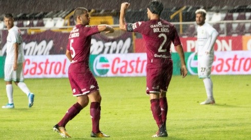 Saprissa's players celebrate a goal by touching elbows