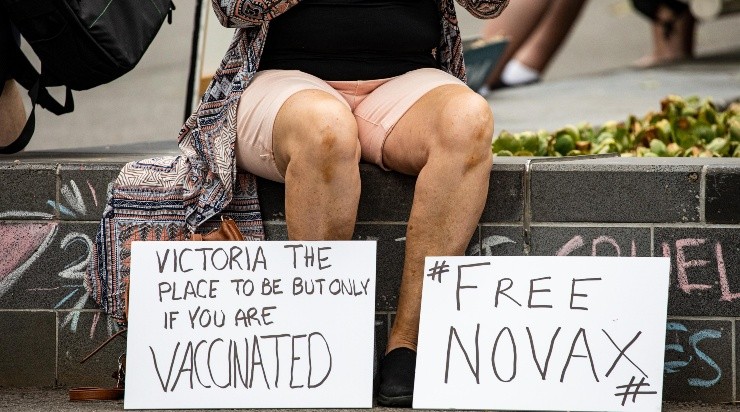 Un partidario de Djokovic muestra carteles contra la vacunación (Getty)