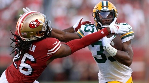 Aaron Jones #33 of the Green Bay Packers carries the ball fighting off the tackle of Josh Norman #26 of the San Francisco 49ers.