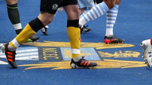 Players walk over the Manchester City's old crest