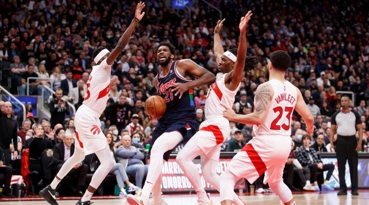 Joel Embiid #21 of the Philadelphia 76ers drives to the net against Chris Boucher #25 and Precious Achiuwa #5 of the Toronto Raptors (Photo by Cole Burston/Getty Images)