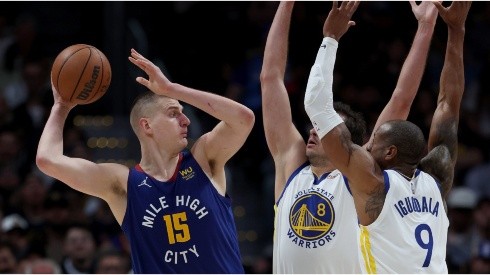 Nikola Jokic of the Denver Nuggets is guarded by Nemanja Bjelica and Andre Iguodala of the Golden State Warriors