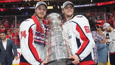 John Carlson (left) and Andre Burakovsky of the Washington Capitals pose with the Stanley Cup trophy in 2018.
