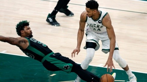 The Bucks Giannis Antetokounmpo (right) was called for a first quarter offensive foul as the Celtics Marcus Smart (left) hits the floor.