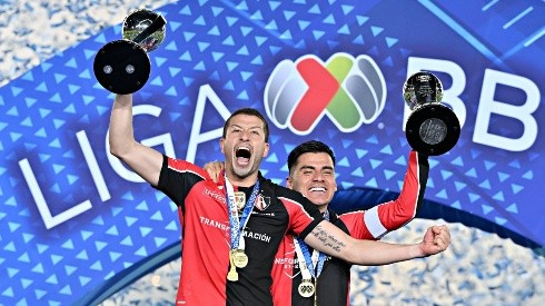 Hugo Nervo y Aldo Rocha levantan los trofeos de campeón.