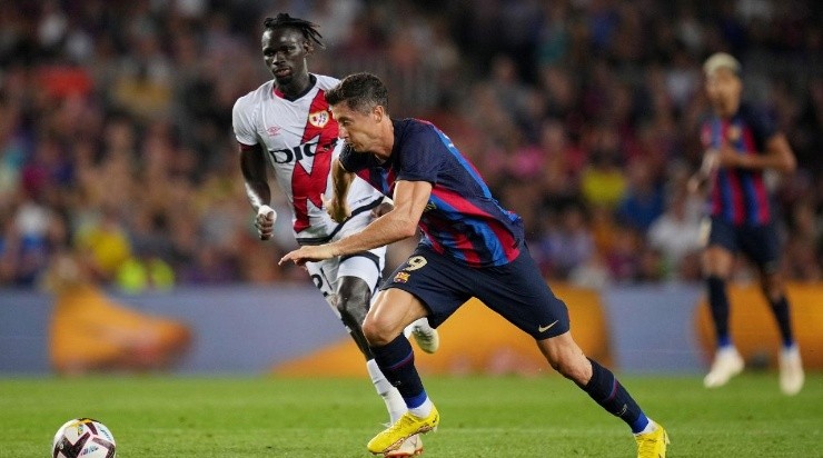 Robert Lewandowski of FC Barcelona is challenged by Pathe Ciss of Rayo Vallecano during the LaLiga Santander match (Photo by Alex Caparros/Getty Images)