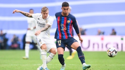 Toni Kroos of Real Madrid CF competes for the ball with Ferran Torres of FC Barcelona