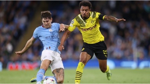 John Stones of Manchester City is challenged by Donyell Malen of Borussia Dortmund