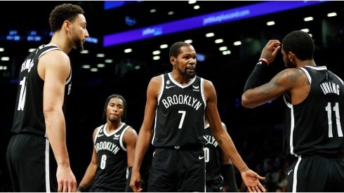 Kevin Durant talks with Ben Simmons and Kyrie Irving of the Brooklyn Nets