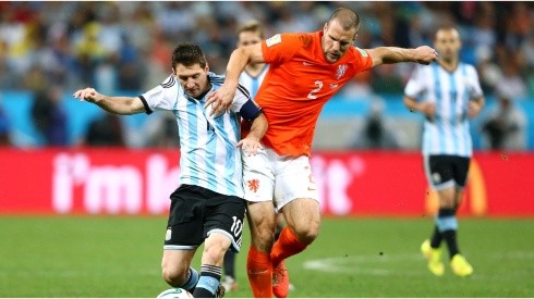 Lionel Messi of Argentina is challenged by Ron Vlaar of the Netherlands during the 2014 FIFA World Cup Brazil Semi Final