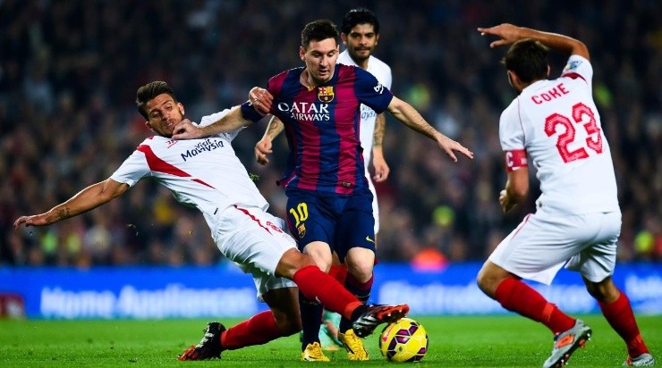 Lionel Messi of FC Barcelona duels for the ball with Daniel Filipe Martins Carrico (L) and Jorge Andujar Moreno ‘Coke’ of Sevilla FC (Photo by David Ramos/Getty Images)