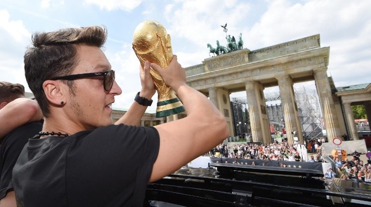 Mesut Oezil celebrates on the open top bus at the German team victory ceremony on July 15, 2014 in Berlin, Germany. Germany won the 2014 FIFA World Cup Brazil match against Argentina in Rio de Janeiro on July 13. (Photo by Markus Gilliar - Pool/Getty Images)