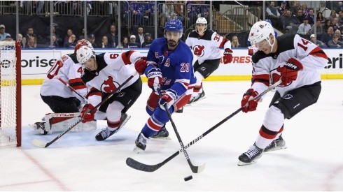 Chris Kreider #20 of the New York Rangers and Nathan Bastian #14 of the New Jersey Devils battle for the puck