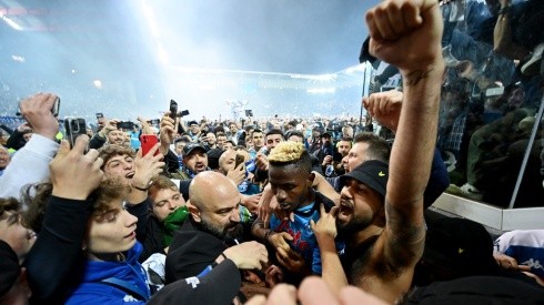Victor Osimhen of SSC Napoli is surrounded by SSC Napoli fans who celebrate the Serie A title.