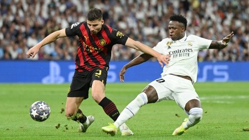 Ruben Dias of Manchester City is challenged by Vinicius Junior of Real Madrid