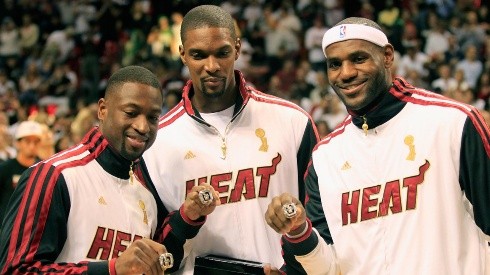 Dwyane Wade, Chris Bosh y LeBron James muestran el anillo de campeones de la NBA.