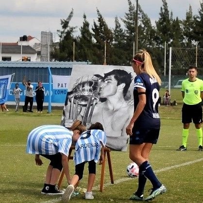 El femenino de Racing también le rindió homenaje al Chango Cárdenas: sus nietasSol y Emma le dejaron una flor junto con Rocío Bueno (FOTO: Prensa Racing).