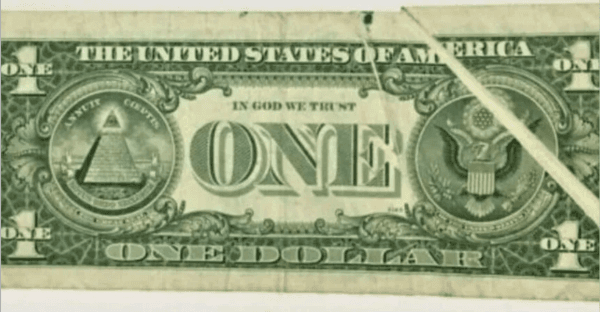 El dorso del billete de 1 dólar con un error de impresión en el vértice.