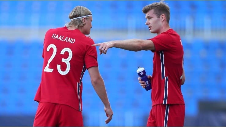 Erling Haaland from Norway talks to teammate Patrick Berg