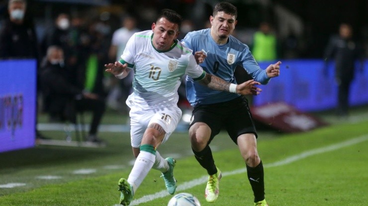 Henry Vaca of Bolivia (left) tries to avoid defender Agustín Alvarez Martínez of Uruguay during a game for the Qualifiers on September 5