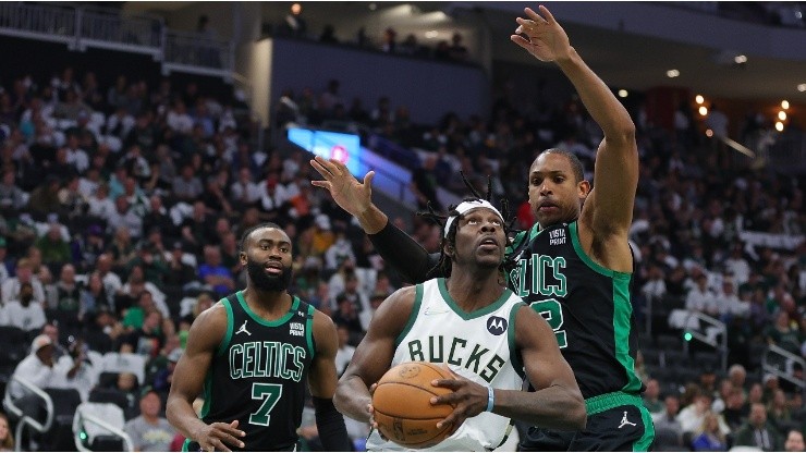Jrue Holiday of the Milwaukee Bucks is defended by Al Horford and Jaylen Brown of the Boston Celtics