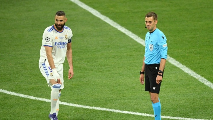 Karim Benzema of Real Madrid and Referee Clement Turpin look on as they wait for the result of a VAR review