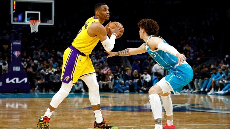 Russell Westbrook of the Los Angeles Lakers looks over the court as he is guarded by LaMelo Ball of the Charlotte Hornets