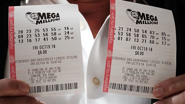A customer holds up his Mega Millions lottery tickets at a convenience store