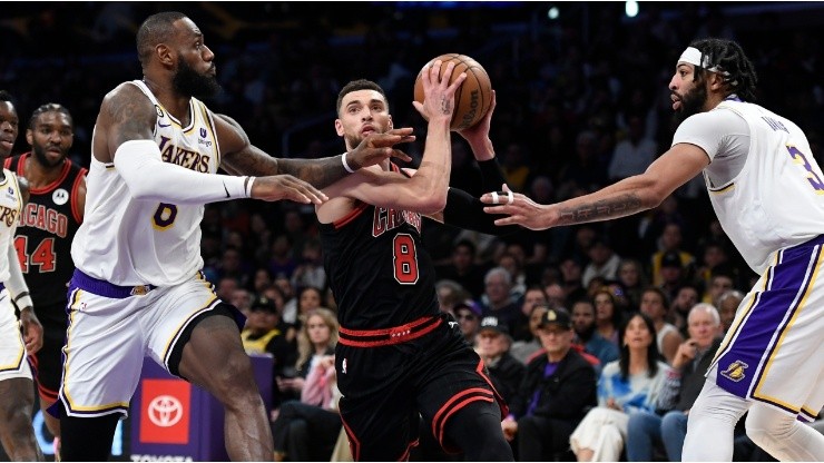 Zach LaVine #8 of the Chicago Bulls drives to the basket in between LeBron James #6 and Anthony Davis #3 of the Los Angeles Lakers
