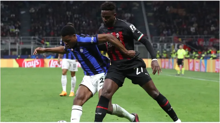 Denzel Dumfries of FC Internazionale is challenged by Divock Origi of AC Milan
