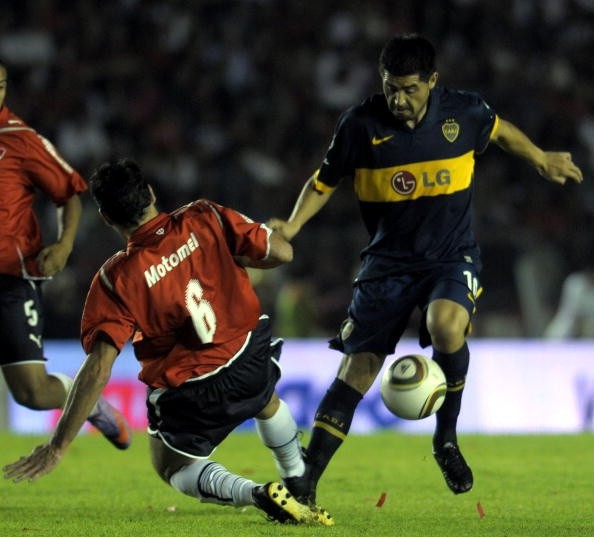 Riquelme pelea la pelota con Eduardo Tuzzio, en una de las últimas visitas del enganche al Libertadores de América.